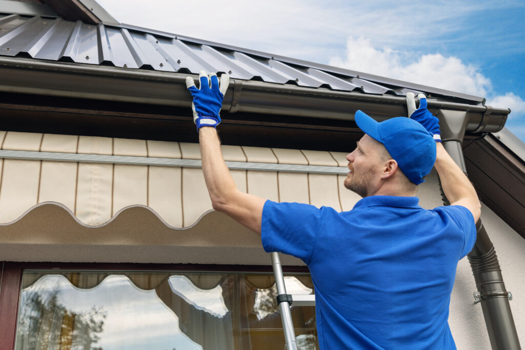 man cleaning gutters